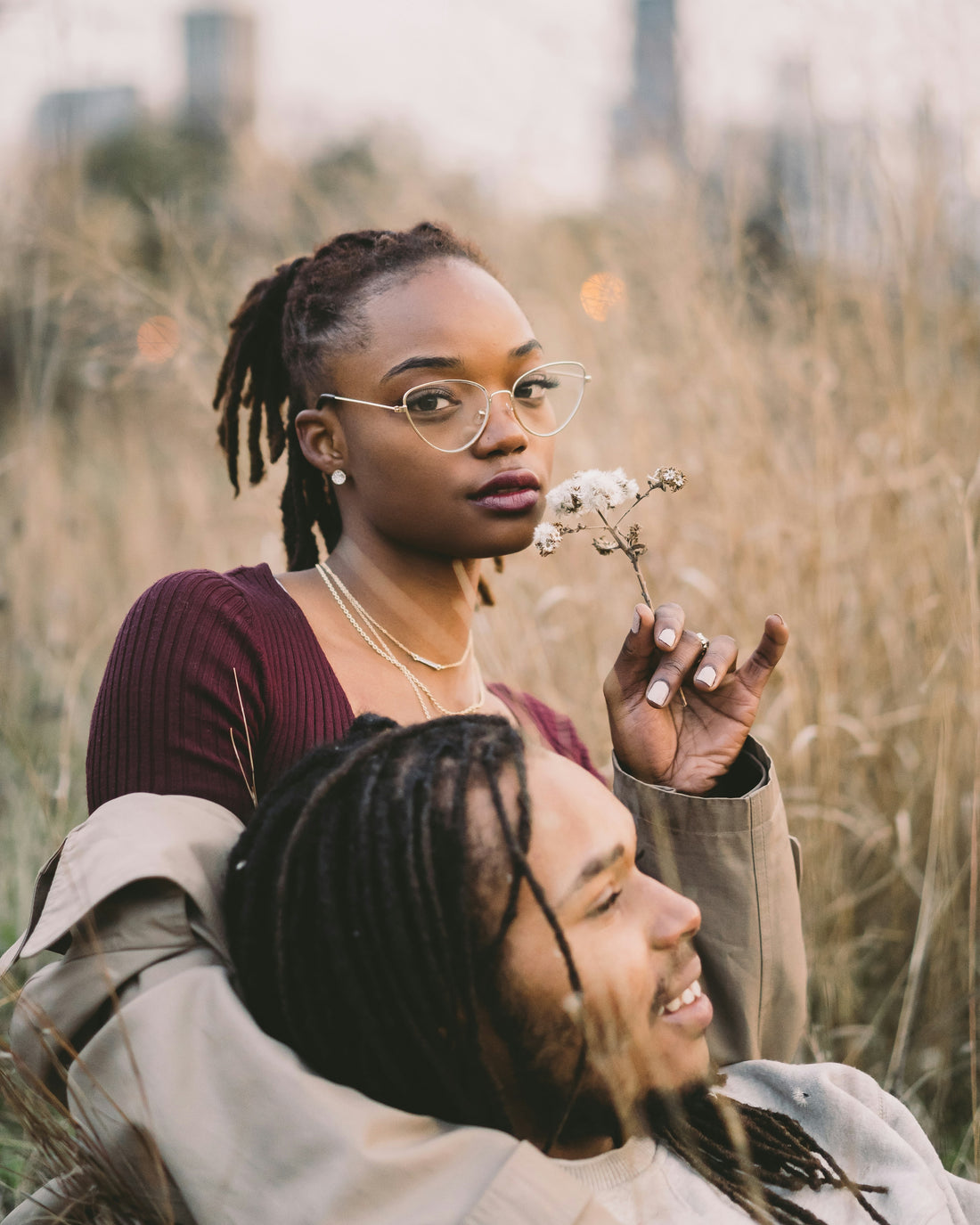 Newly Engaged beautiful Black couple sitting in a field of flowers embracing. Discussing their wedding plans.