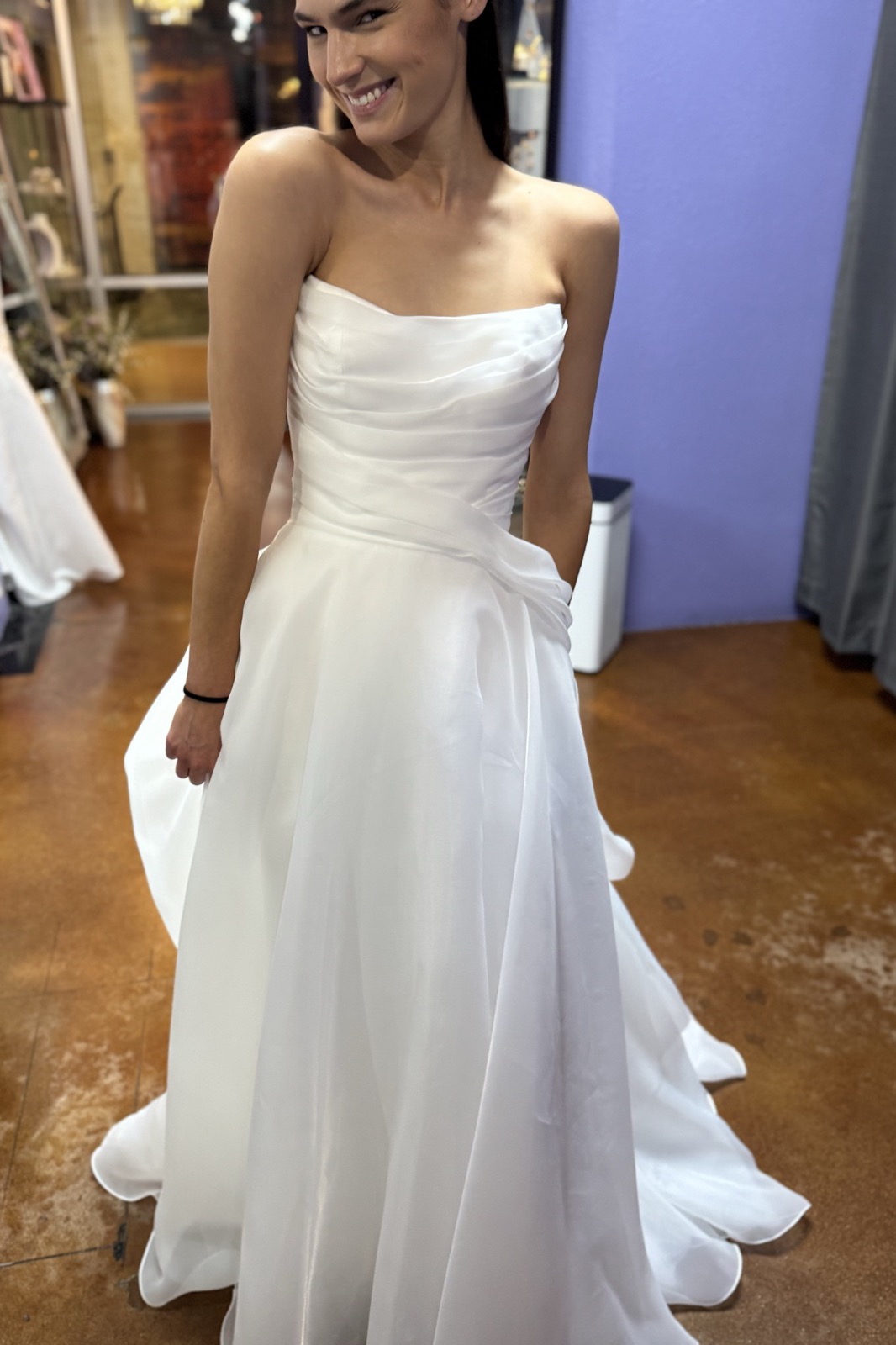 Smiling bride in a strapless organza ballgown during her fitting at Margo West Bridal Couture, Dallas TX